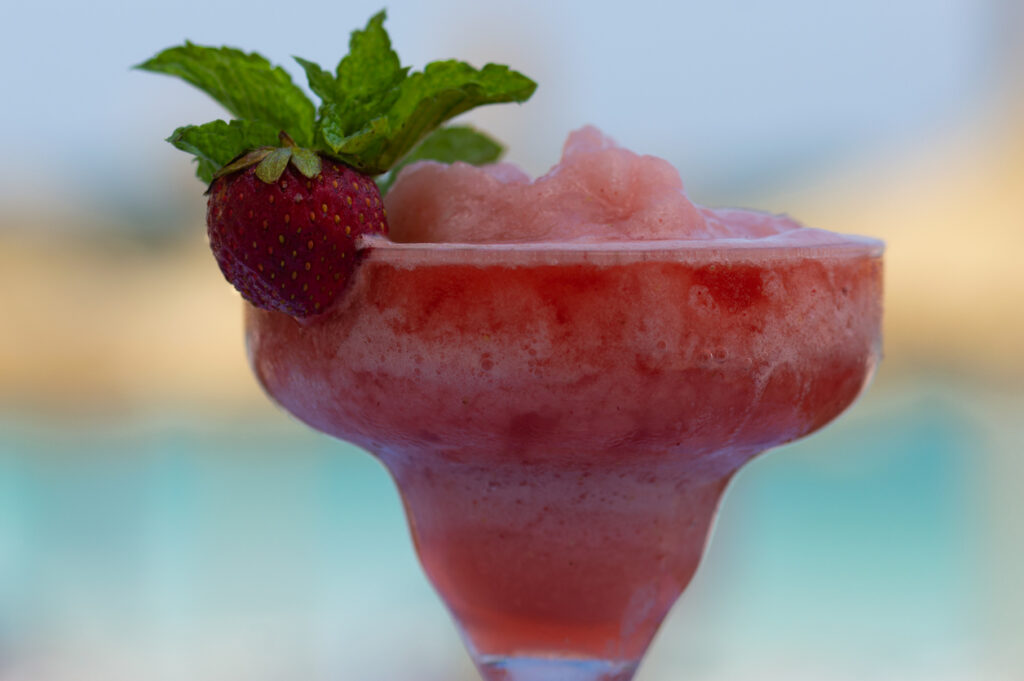 delicious summer cocktail. slushy strawberry daiquiri with blurred background