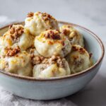 Soft cottage cheese protein dumplings in a bowl topped with savory ground turkey crumbles and melted cheese.