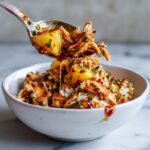 Rotisserie chicken chili crisp pineapple protein bowl with shredded rotisserie chicken, pineapple chunks, rice and chili crisp oil drizzle