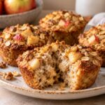 Apple cinnamon baked oatmeal cups with diced apple and walnuts on a plate, one cup broken open